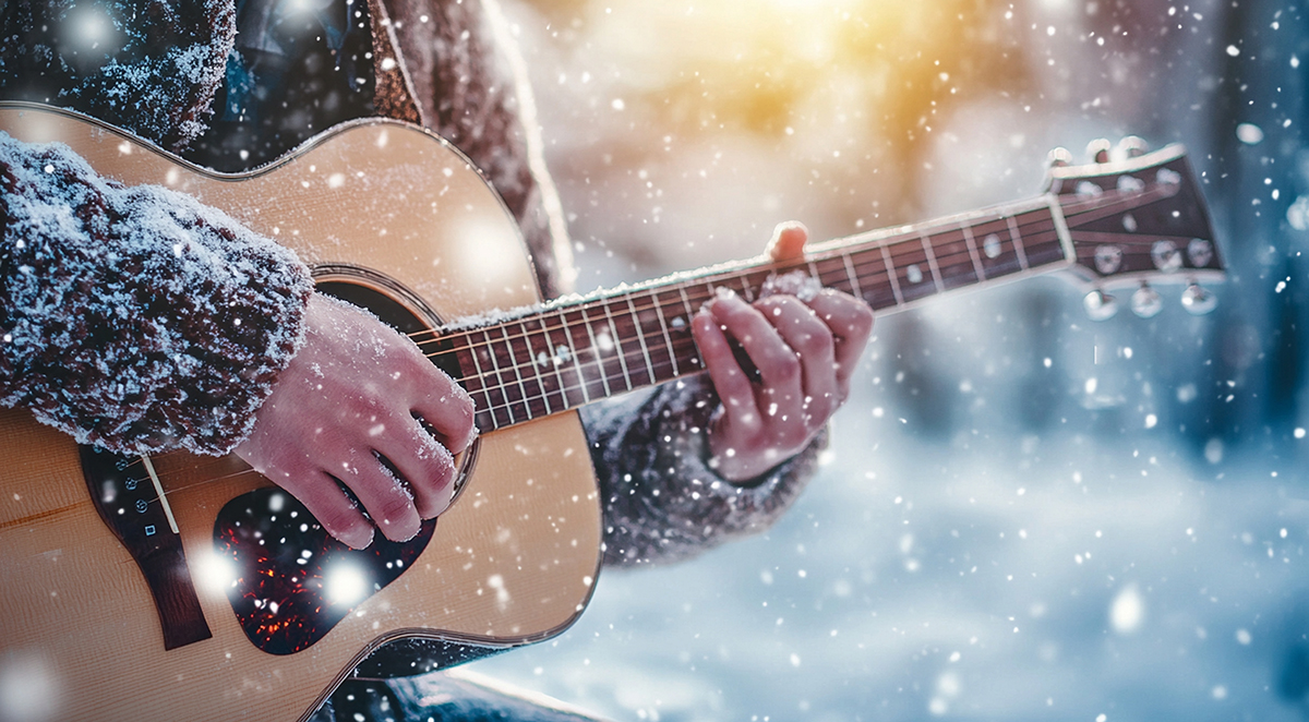 five_must-see_holiday_performances_asheville image Man playing guitar during snowfall